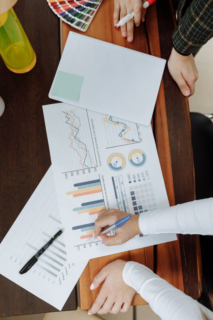 Vue d’en haut d’une équipe d’affaires analysant des graphiques et des données sur papier pour planifier la stratégie.